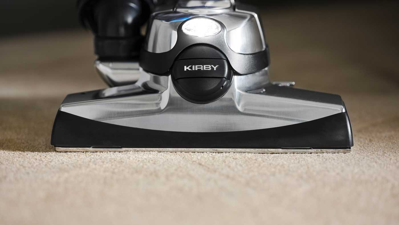 A Kirby vacuum's front hood and head light on a carpet