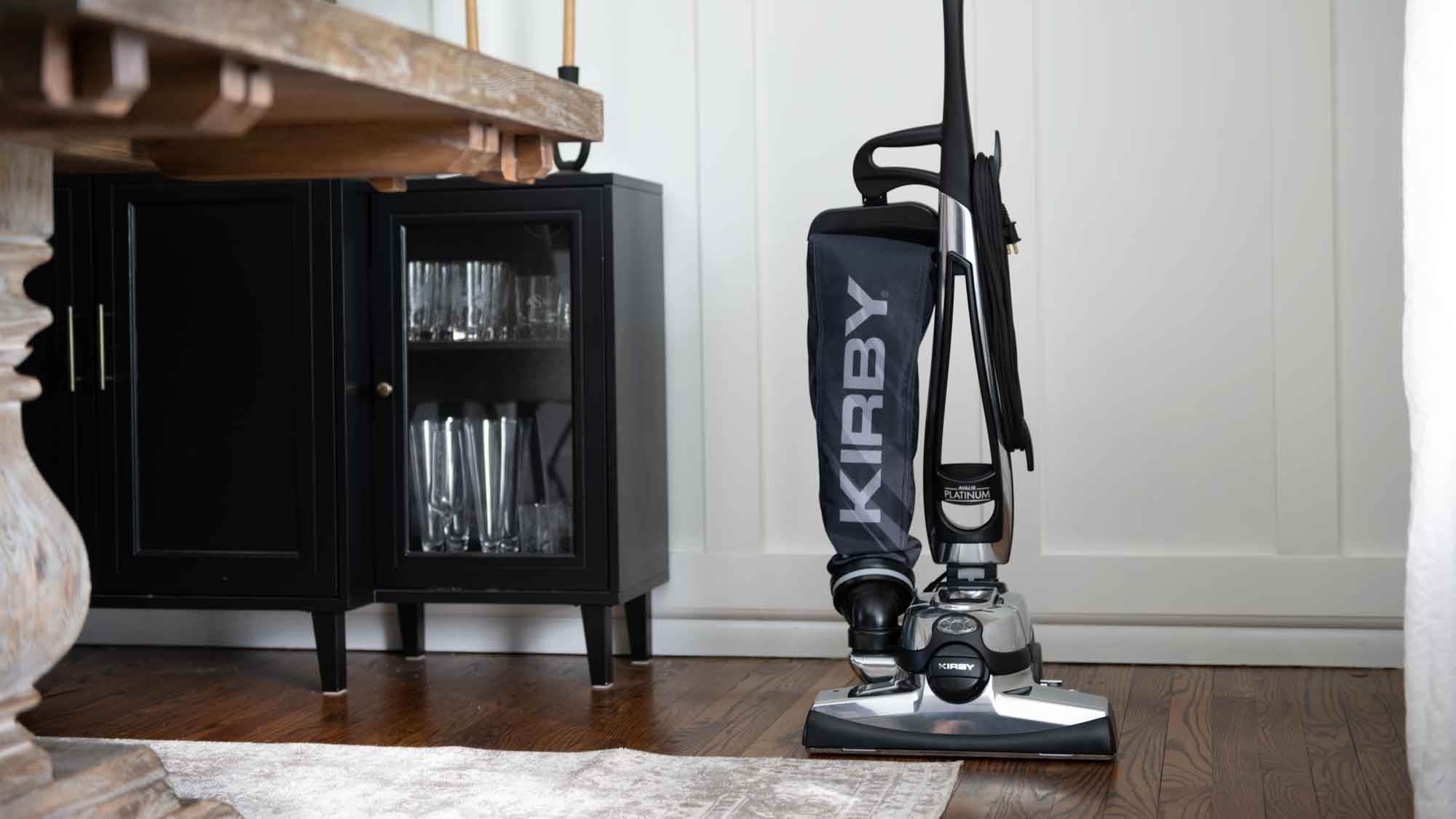 A Kirby vacuum that is sitting on the floor in the living room