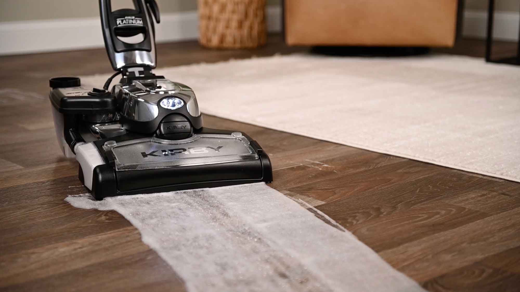 A Kirby vacuum with it's multi-surface shampoo system cleaning a hard wood floor
