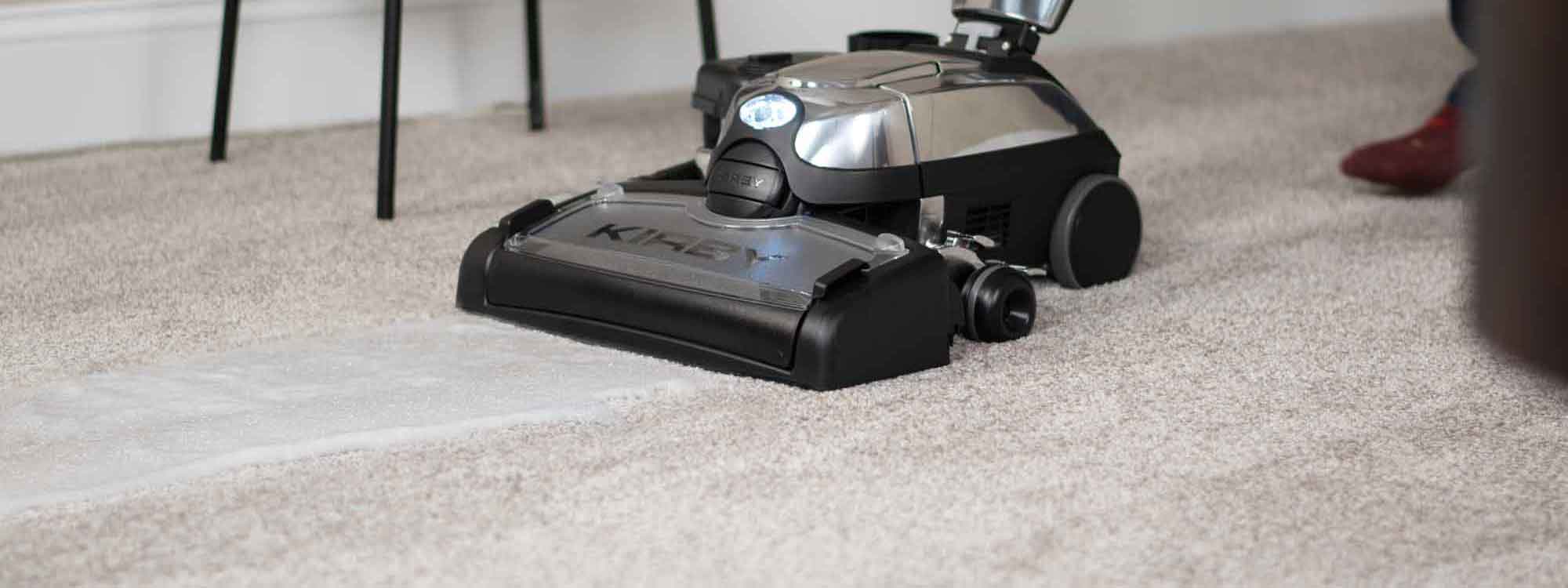 A Kirby vacuum with it's multi-surface shampoo system attached shampooing carpet