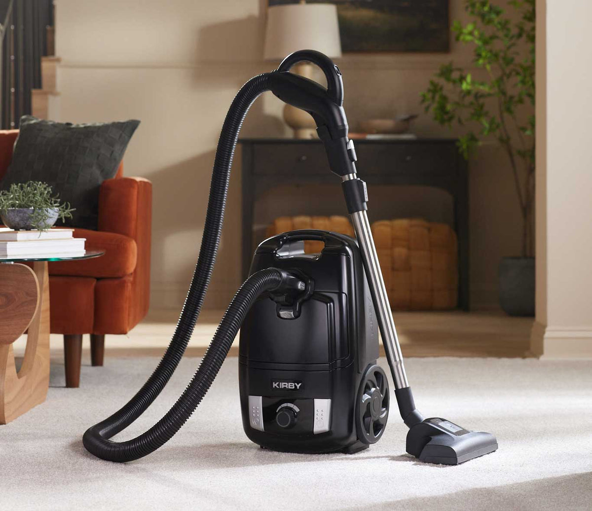 Kirby Signature Series C530 canister vacuum cleaner, shown on a light-colored carpet in a cozy living room setting.