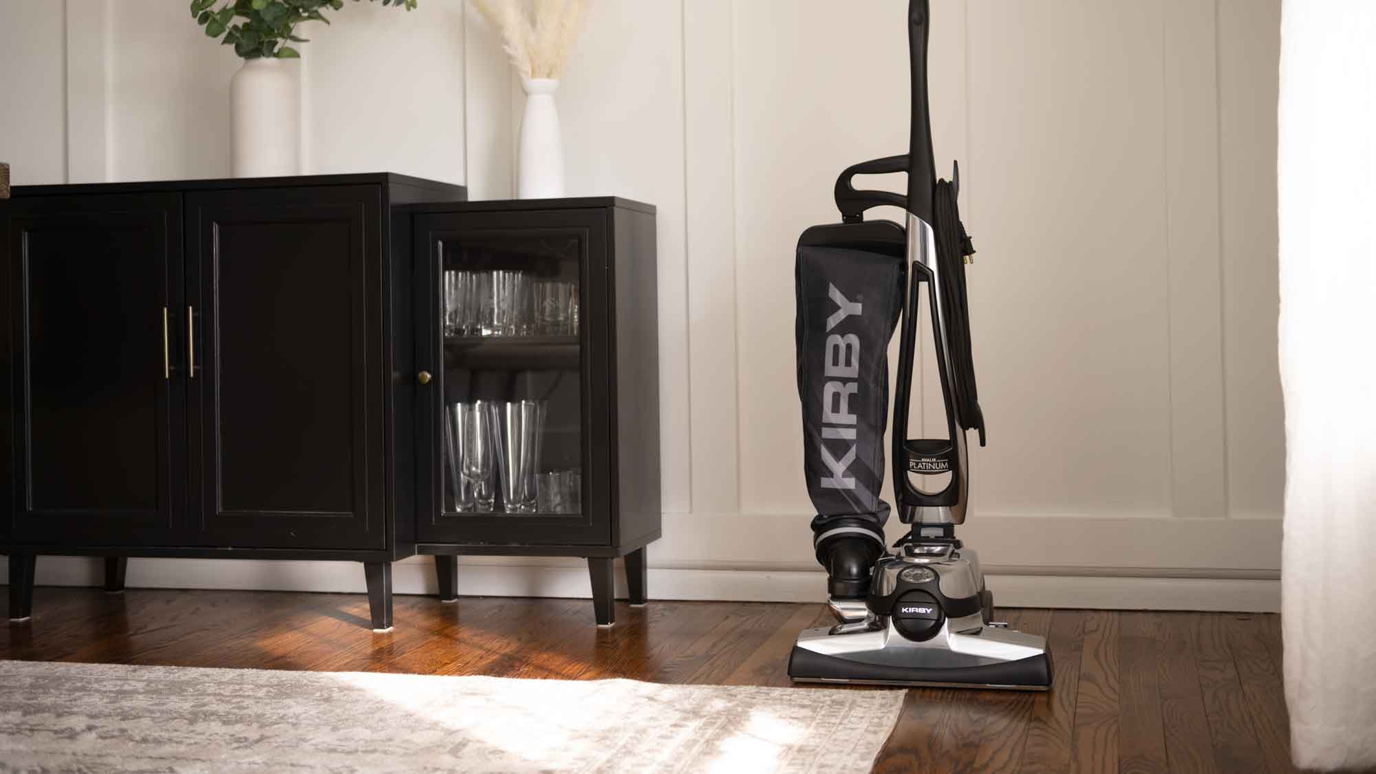A Kirby vacuum that is sitting on the floor in the living room