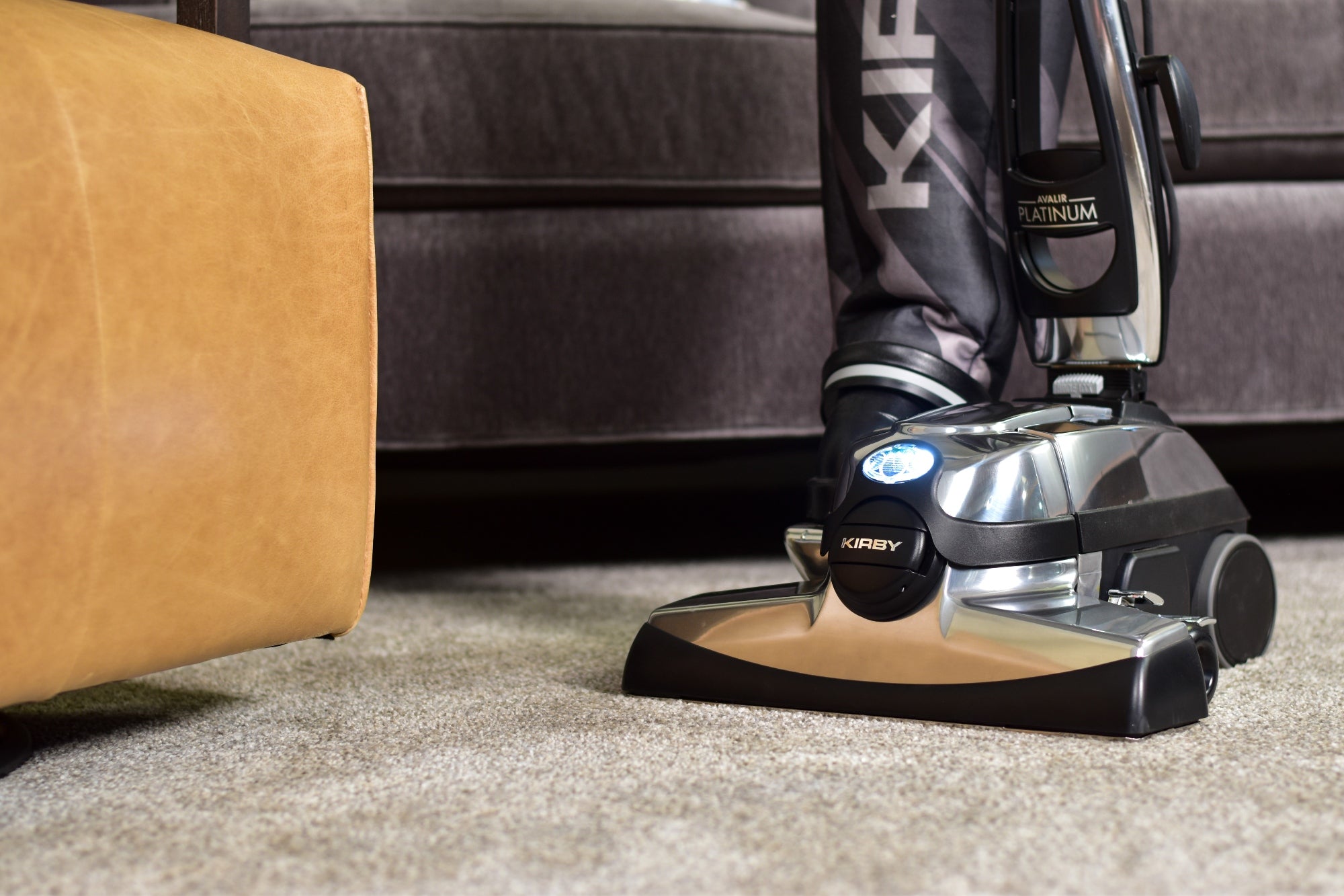 A Kirby vacuum's front hood and head light on a carpet