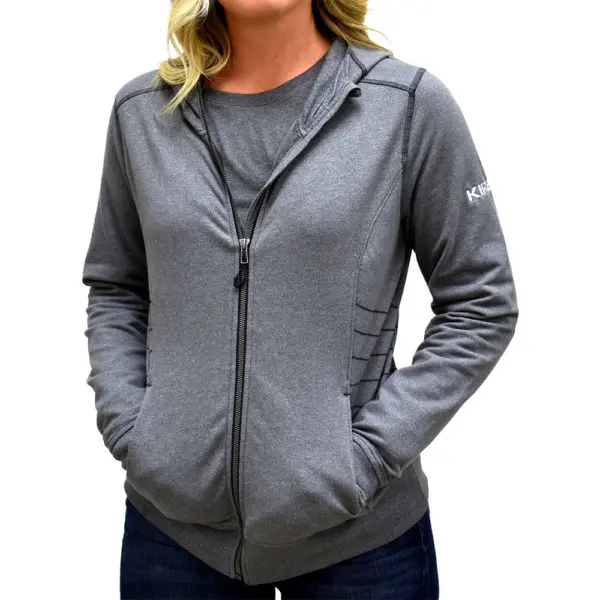 Woman wearing a light gray zip-up hoodie with Kirby logo on the sleeve.