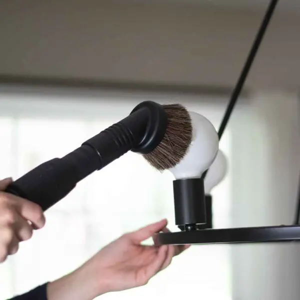 Close-up of a Kirby vacuum dust brush cleaning a white globe.