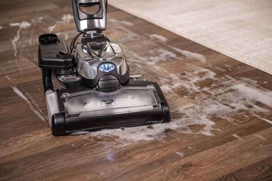 Kirby Avalir Platinum Upright vacuum cleaning a hardwood floor.