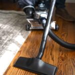 Kirby vacuum in canister mode cleaning a hardwood floor.