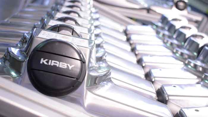 Close-up of Kirby vacuum parts with aluminum construction and black Kirby logo.