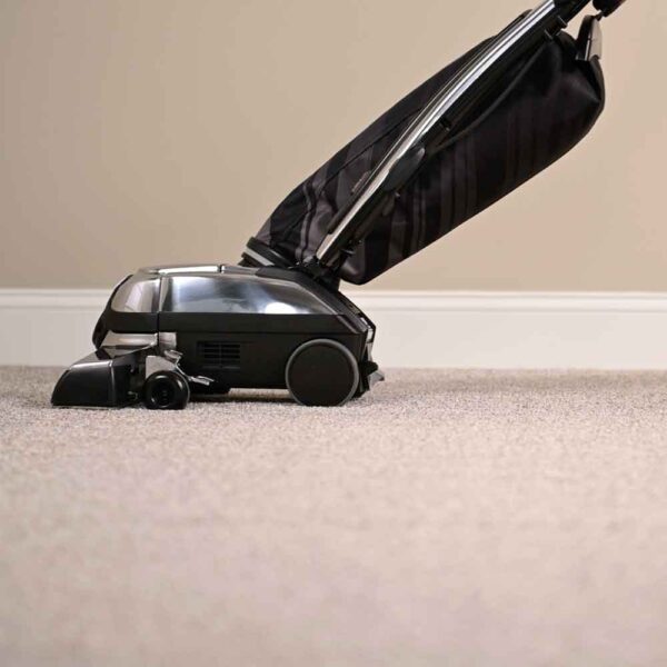 Silver and black Kirby vacuum cleaner on carpet.